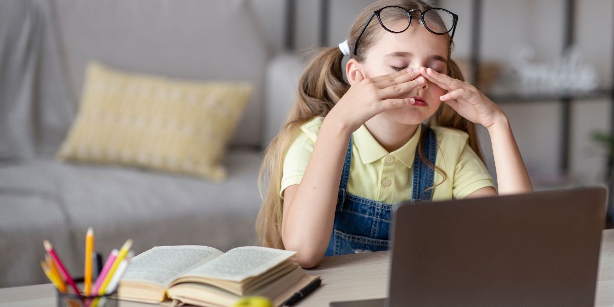 School age girl rubbing her eyes 