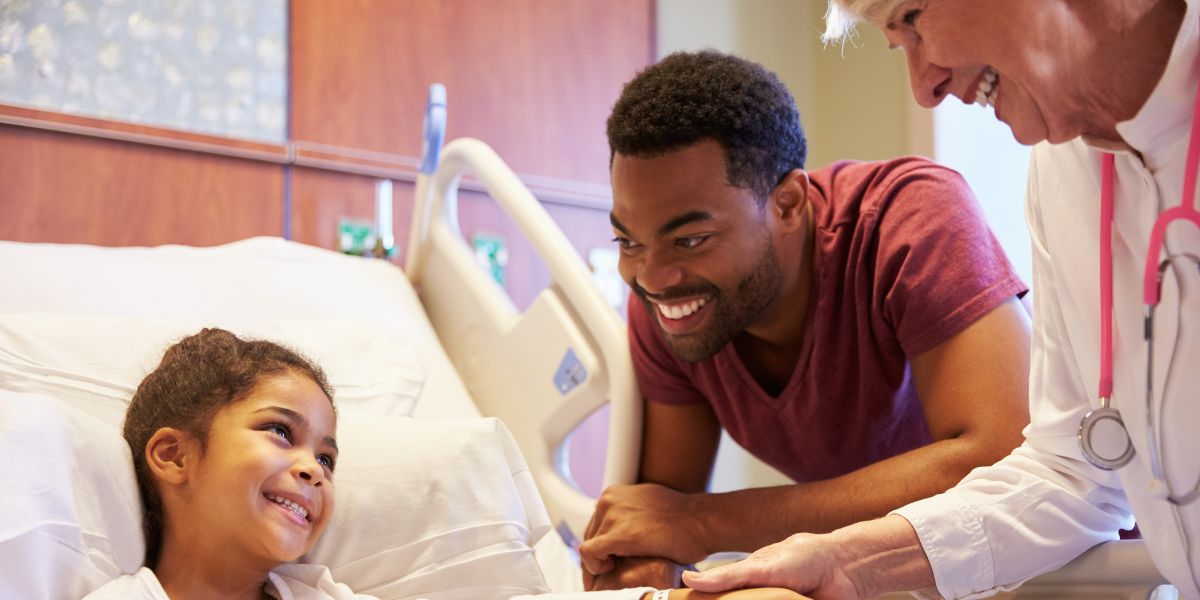 Parent and kid with clinician at hospital