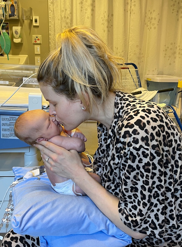 Sophie kisses her newborn baby Charlie in the hospital.