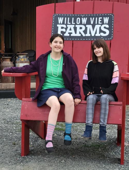 Sierra and Danica sitting in a red chair 