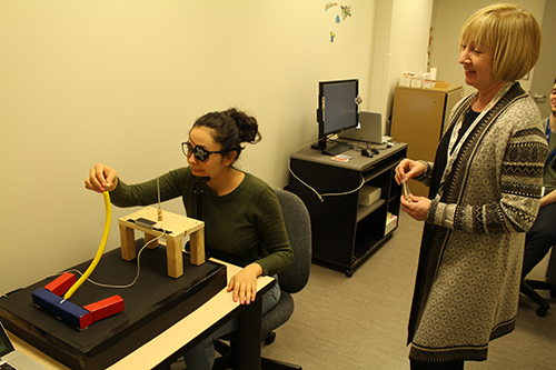 Professor Deborah Giaschi and research assistant Mayela Sosa demonstrating a device used to assess hand-eye coordination