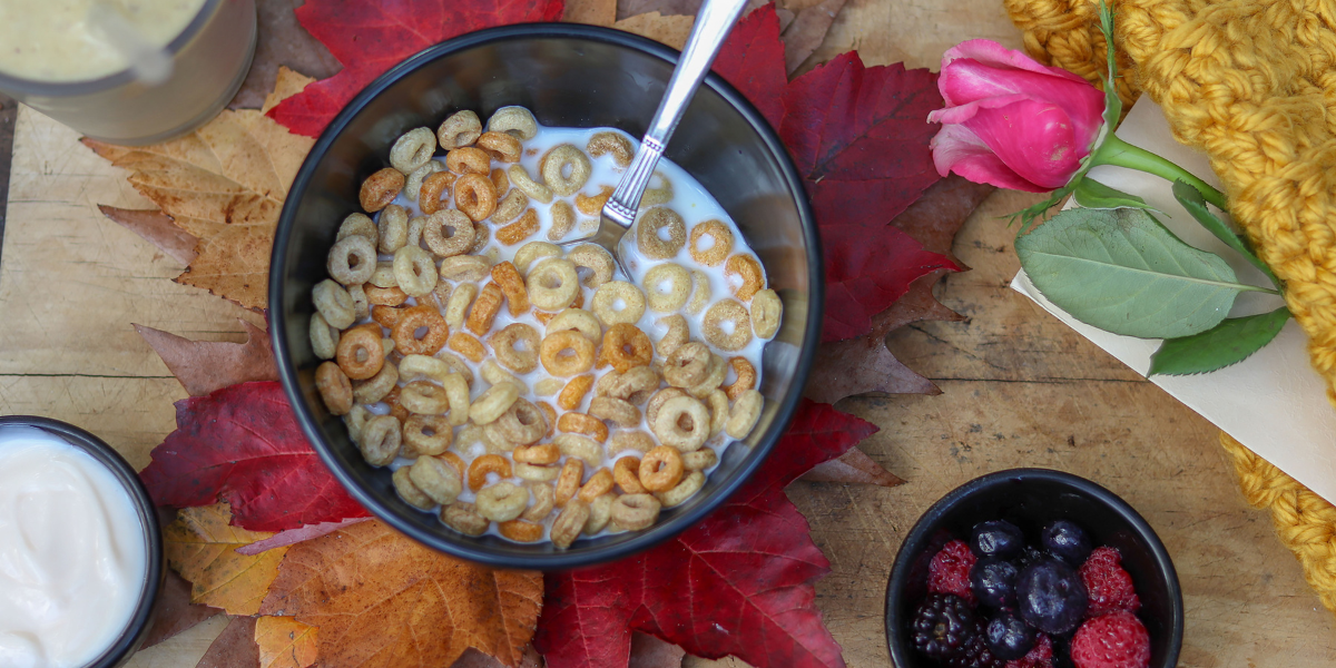 Looking down at a bowl of O-shaped cereal on a seasonally decorated dining table.