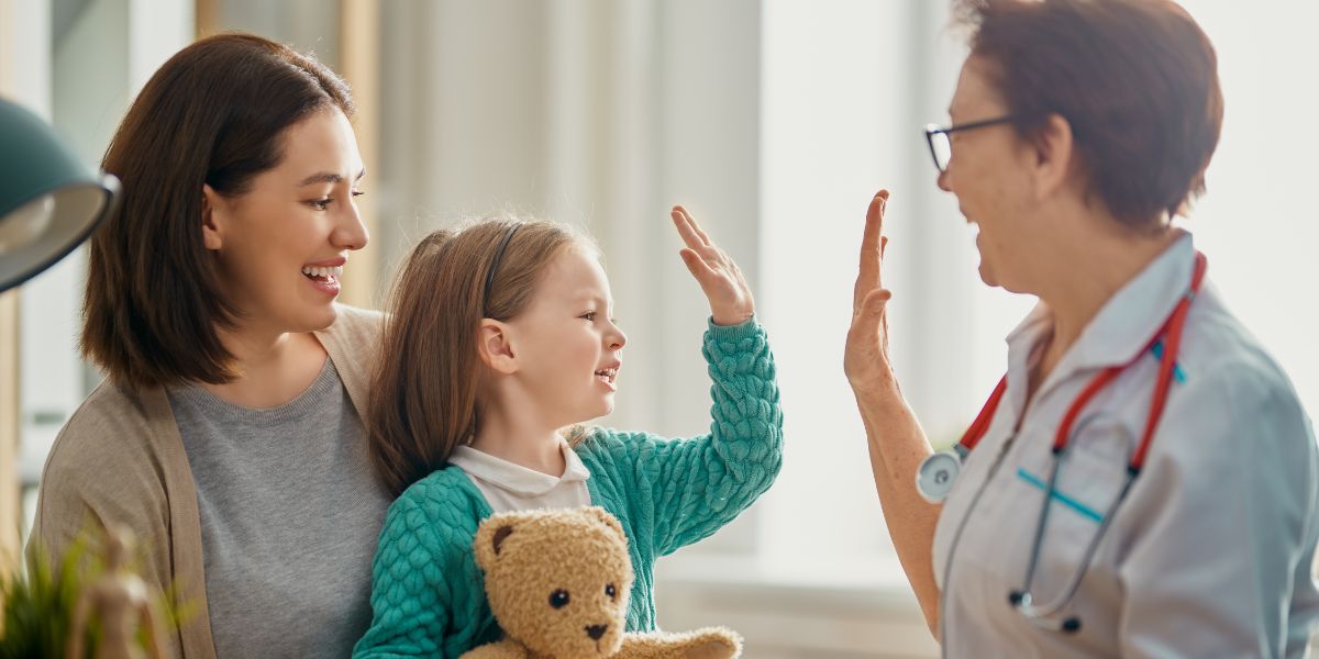 A child patient partner sits with parent and clinician researcher