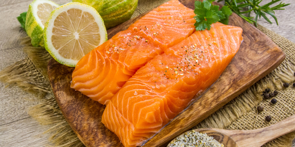 fresh cut salmon on a wooden plank, salted and ready for cooking