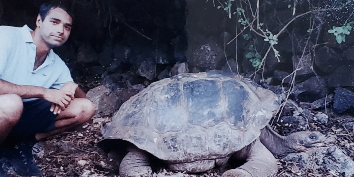 Dr. Manish Sadarangani squatting next to a giant tortoise