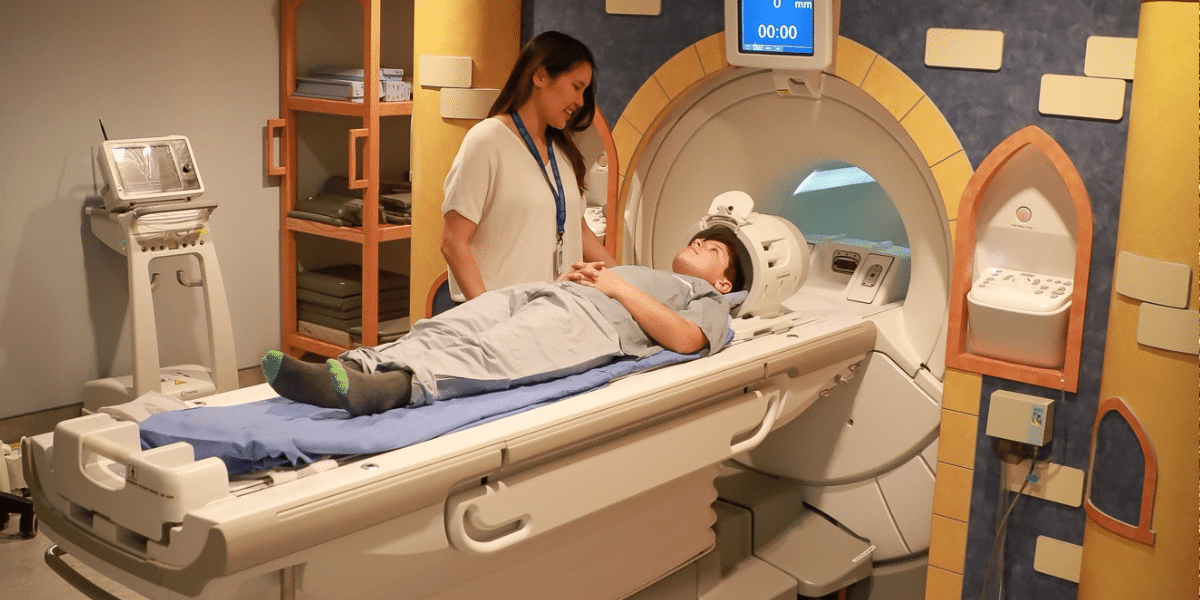 A health-care worker with a child going into an MRI machine
