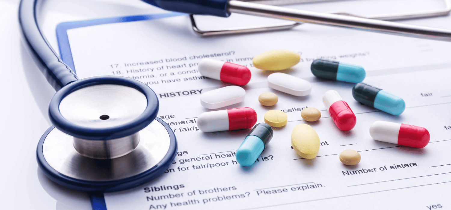 A stethoscope and pills on top of a medical form