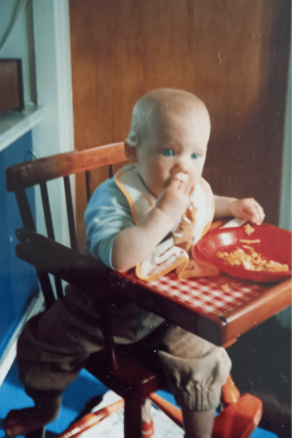 Dr. Genelle Lunken as a baby eating in her highchair