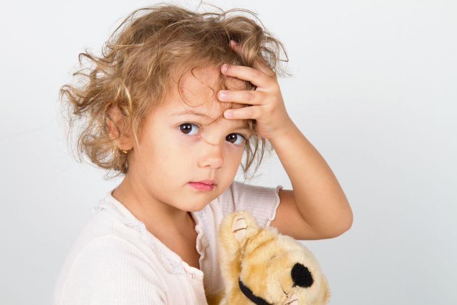 Young child holding their head