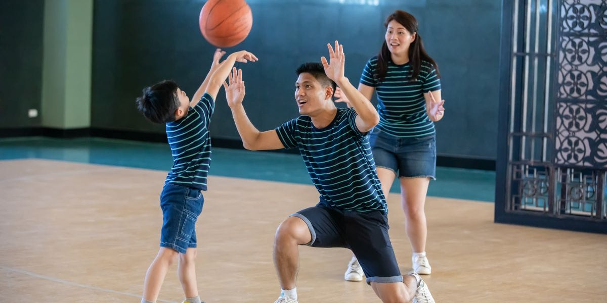 Parents playing basketball with child